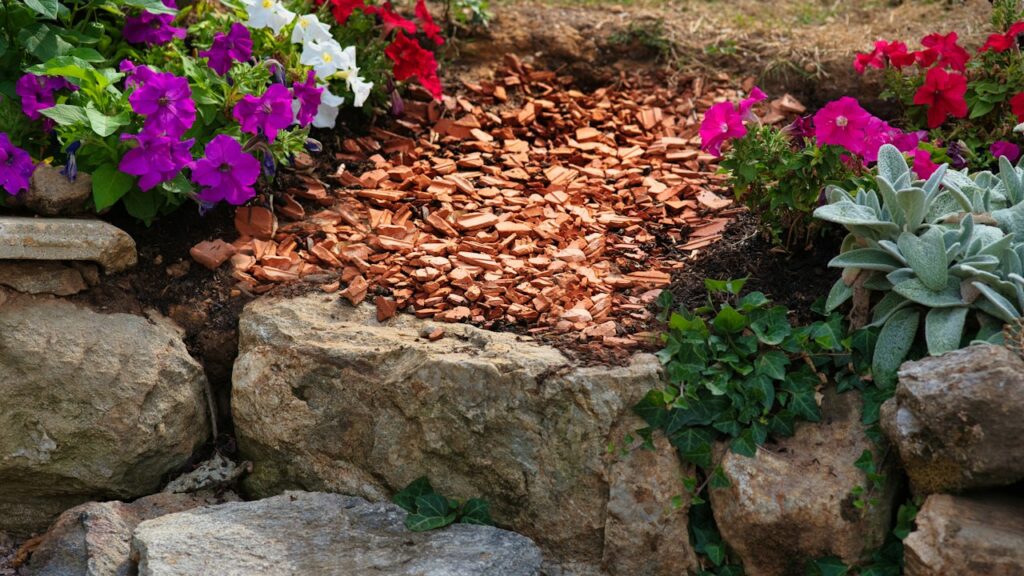 Parterre con acolchado mineral entre plantas y rocas